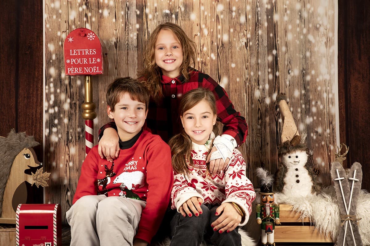 Exemple de photo de fratrie : 3 enfants ensemble dans le même décor de Noël